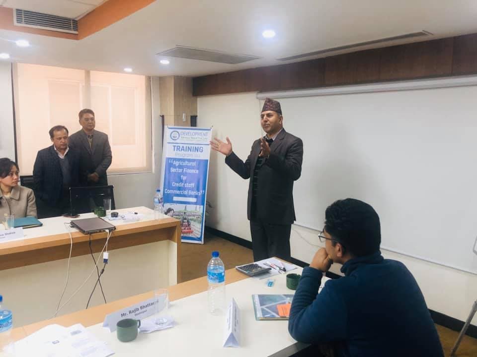 A presenter speaking to seated training participants