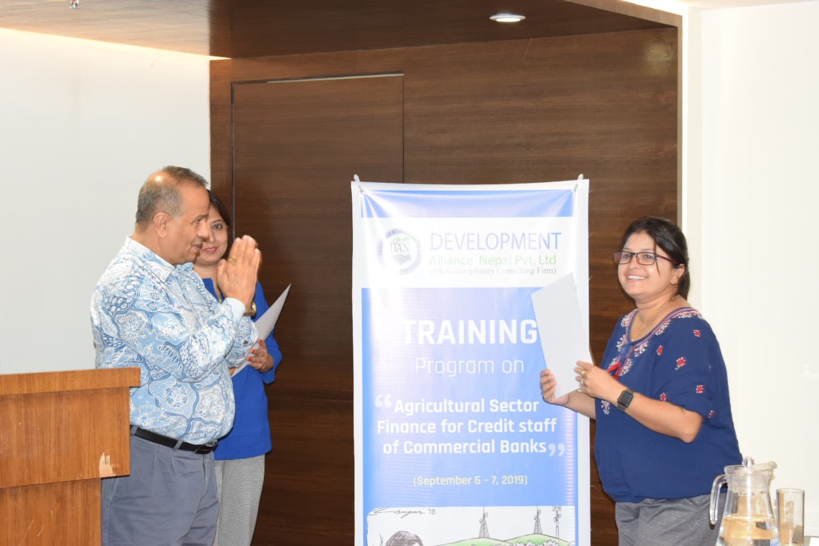 Two facilitators speaking at the front of a training room